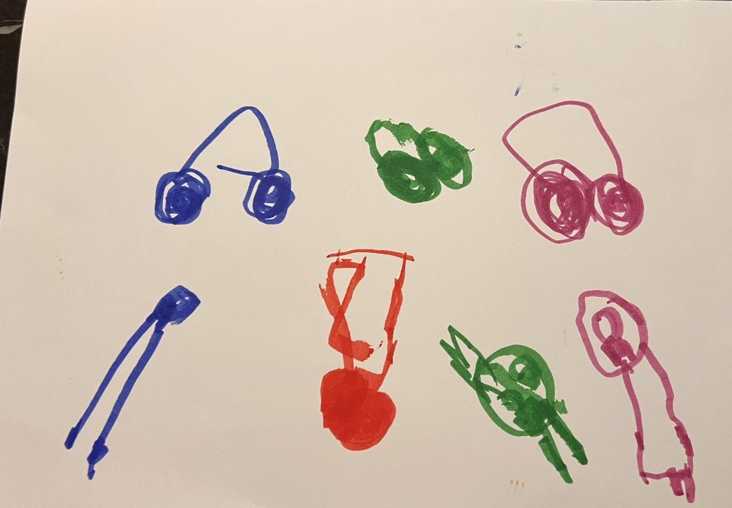 Colorful marker drawings of multiple figures in blue green red and pink showing children experimenting with representing people and objects